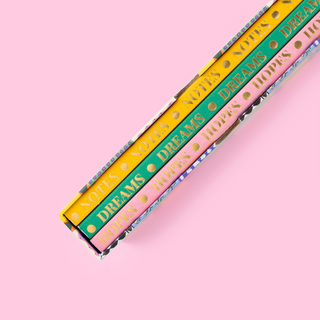 Three colourful Eleanor Bowmer notebooks with gold lettered spines on pink background