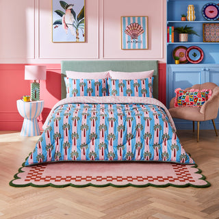 Bedroom with pink walls, green headboard, and colourful bedding